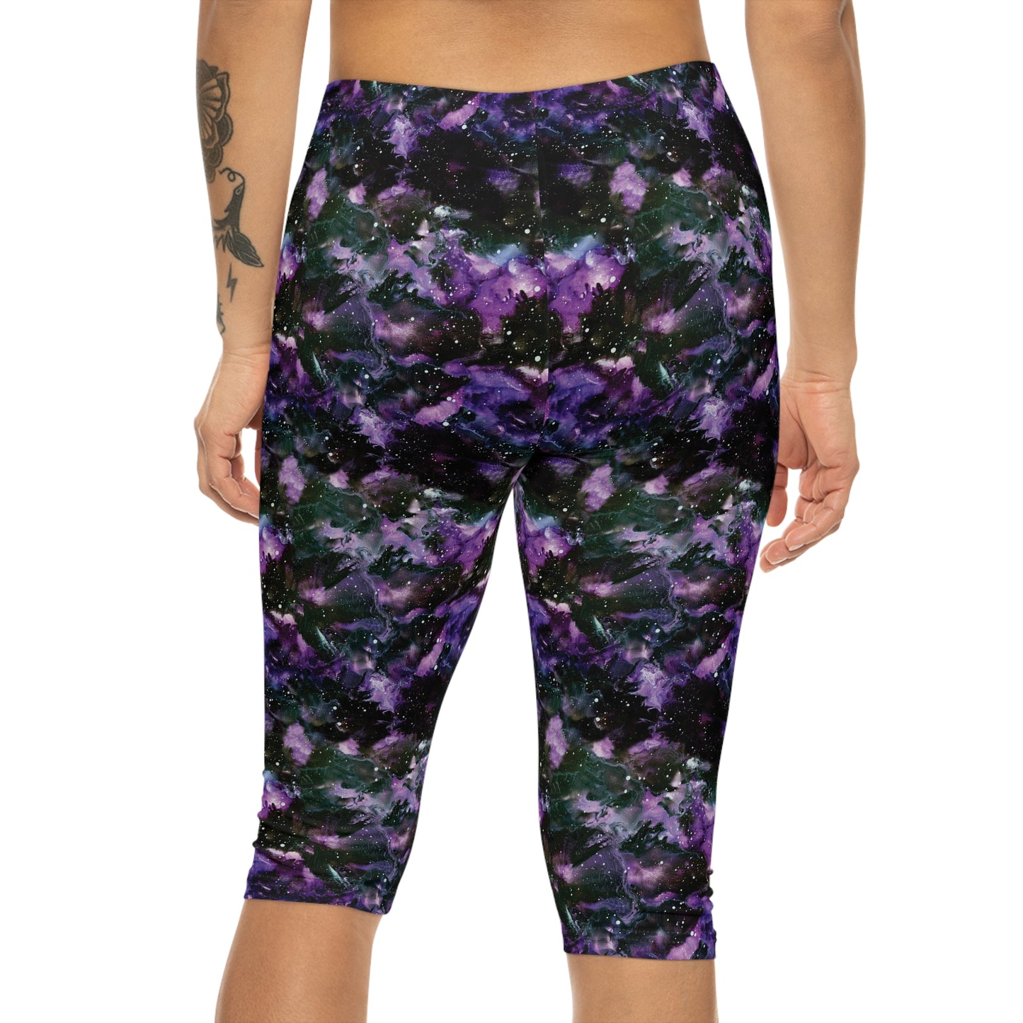 Back view of model wearing Purple Storm Capri Leggings by Alisa Marie. Bold galaxy purple and black design, ideal for yoga, fitness, or casual wear.