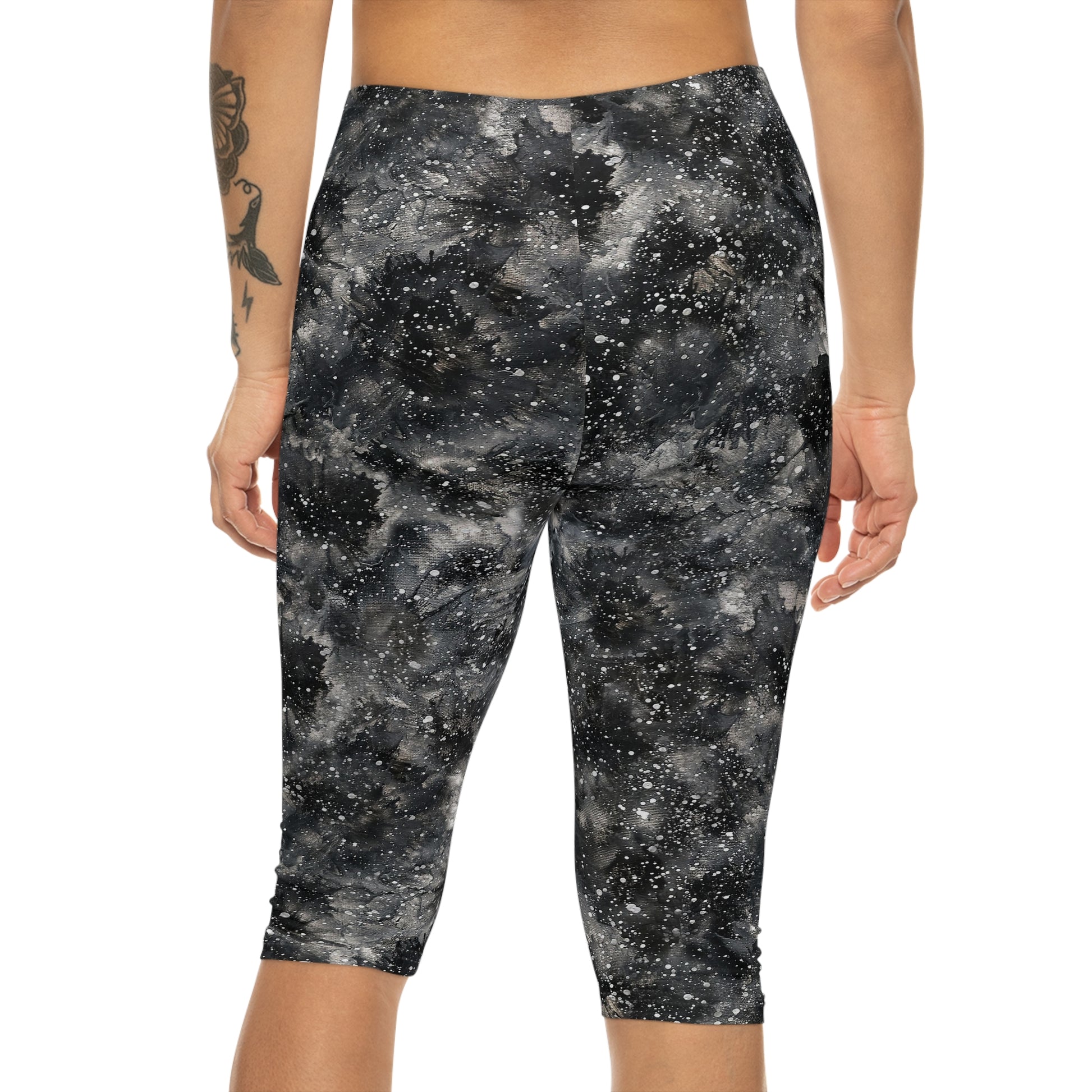 The model is wearing Starry Night Capri Leggings by Alisa Marie. Galaxy-inspired design, perfect for yoga, fitness, and casual wear with vibrant colors.