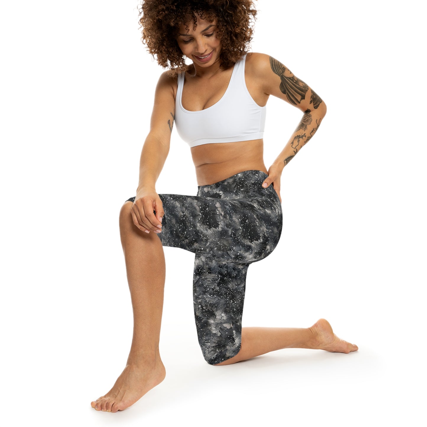 The model is wearing Starry Night Capri Leggings by Alisa Marie. Galaxy-inspired design, perfect for yoga, fitness, and casual wear with vibrant colors.