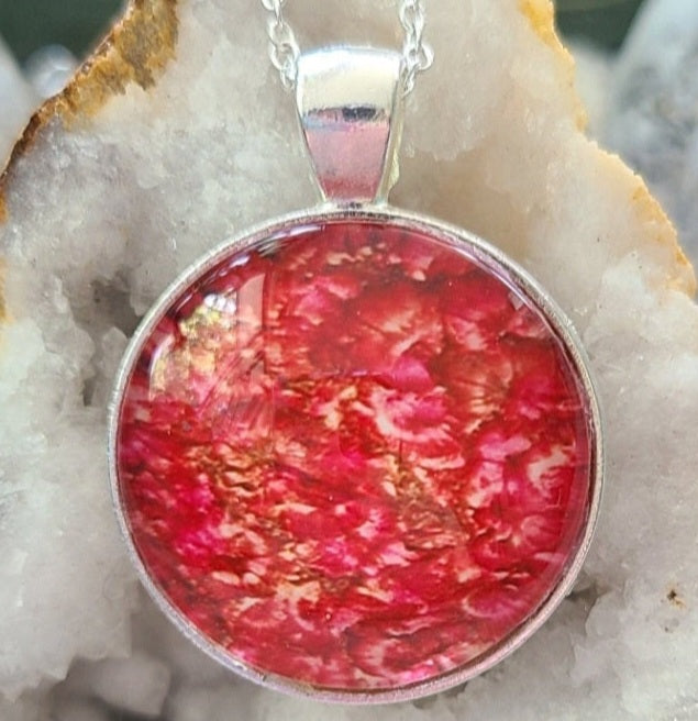 Alisa Marie original artwork pendant, Amore featuring vibrant red and gold tones, set in silver frame with silver chain, displayed on white crystal geode